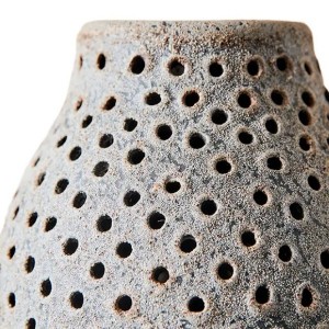 Détail des perforations rondes et de la texture granuleuse de la lanterne Oria en terracotta grey - Muubs - Woodely