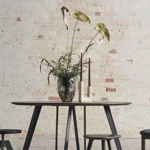 Bougeoir Minerva en travertin crème posé près d'une table avec vase et feuillage, ambiance naturelle - Muubs - Woodely