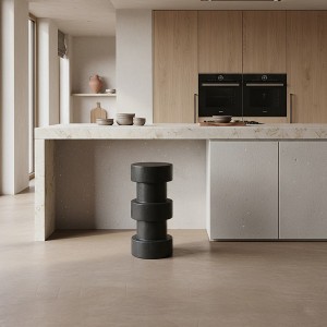 Détail des disques de bois teck empilés du tabouret Forma Totoma noir sur sol béton