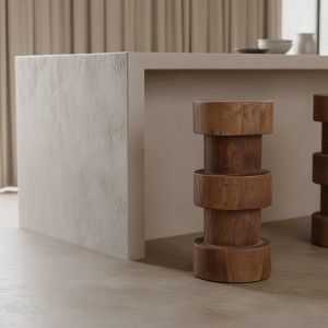 Tabouret bar naturel Forma Totoma utilisé comme table d'appoint décorative au pied d'un canapé bouclé crème