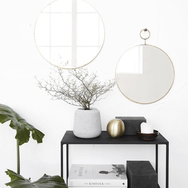 Miroir rond Loop en laiton accroché au mur au-dessus d'une console noire avec vase et branchages - House Doctor - Woodely