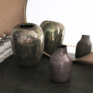 Collection de vases Etnik en laiton aux teintes rouge violet et doré groupés sur un meuble sombre - House Doctor - Woodely