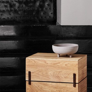 étagère en bois et vase en terre cuite sur trois pieds